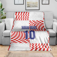 Custom football blanket draped on a sofa, red-and-white checkered pattern with “YOUR TEXT” 10