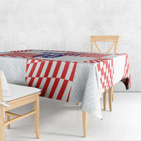 Red-and-white football-themed tablecloth over dining table with side drape