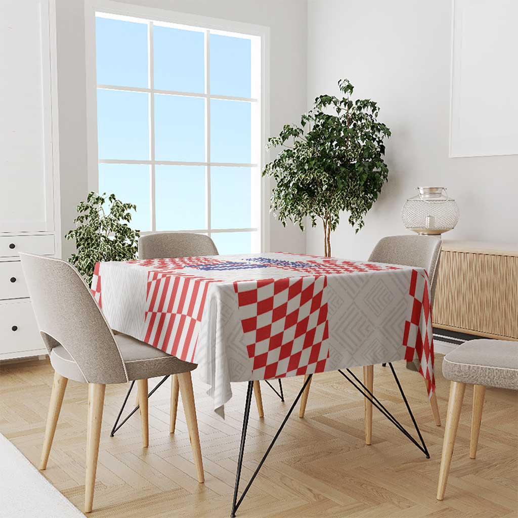 Red-and-white patterned tablecloth on dining table with four chairs