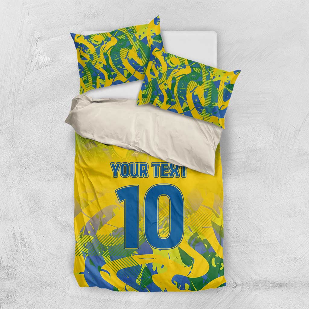 Yellow football bedding set flat-lay with blue-green camo print, 'YOUR TEXT' and large '10'.
