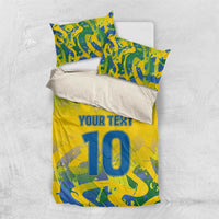 Yellow football bedding set flat-lay with blue-green camo print, 'YOUR TEXT' and large '10'.