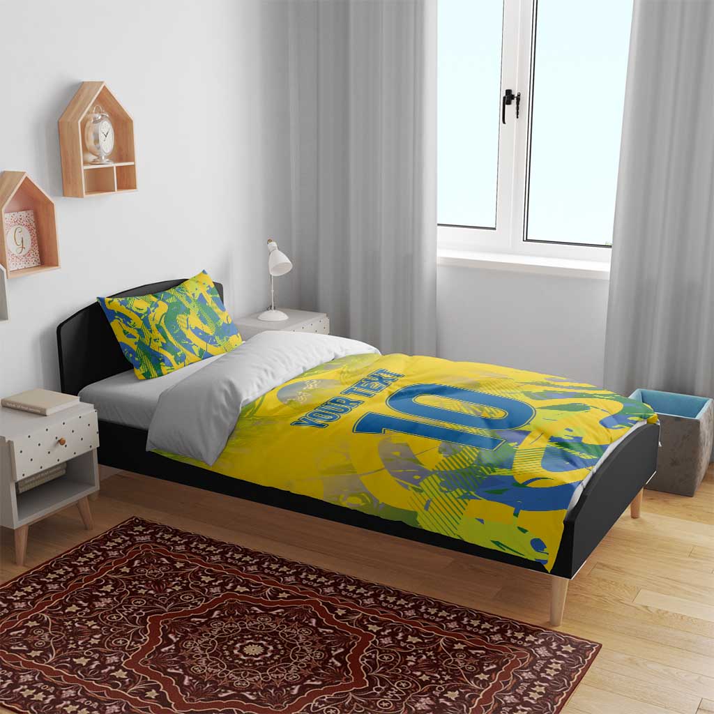 Yellow football bedding set on bed with blue-green camo pattern, 'YOUR TEXT' and large '10'.