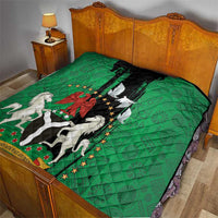 Green quilt on bed with black center panel, peace dove, and Nigeria horse figures