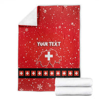 Folded red personalized blanket with Swiss cross, snowflakes, and dark plus stripe