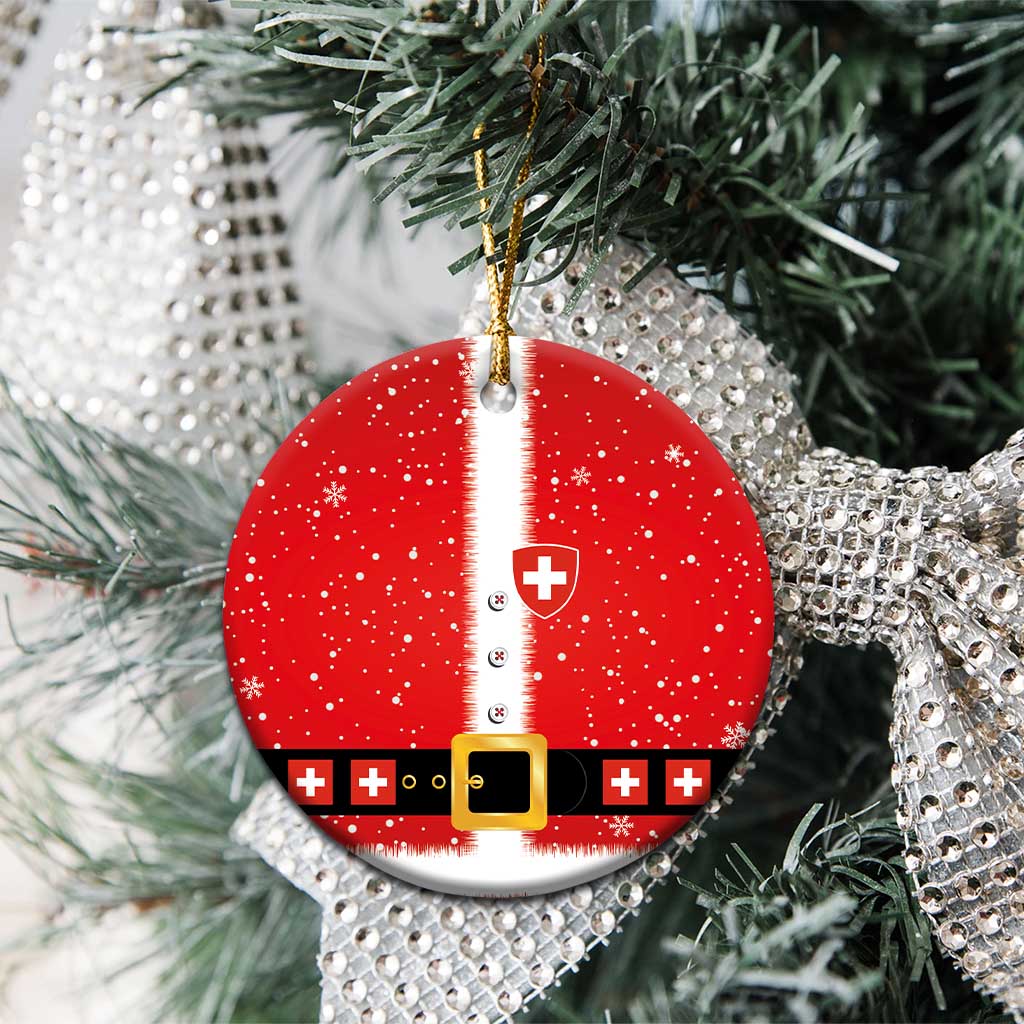 Red round ceramic Swiss-themed Santa suit ornament hanging on evergreen