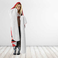 Red hooded blanket with white-fleece lining, worn like a cloak with hood up