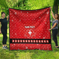 Red quilt with Swiss cross and “YOUR TEXT”, shown flat outdoors
