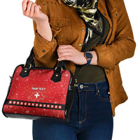 Red holiday handbag held by model; black straps, “YOUR TEXT” and Swiss cross centered.
