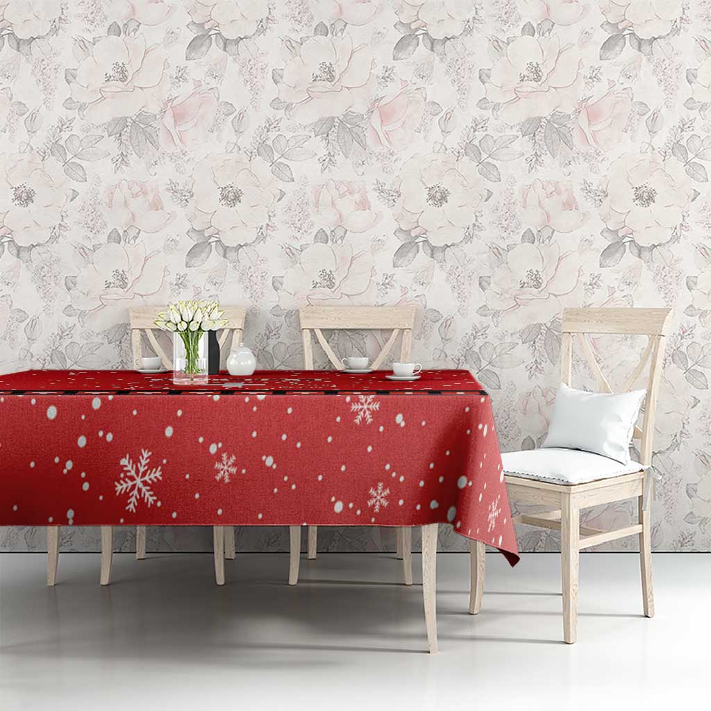 Red snowflake tablecloth with Swiss cross accent, set on dining table with chairs