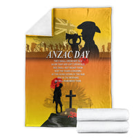 Yellow ANZAC Day blanket folded with white rolled towels, black silhouette and cross