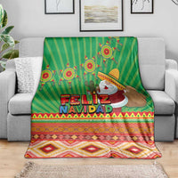 Green holiday throw blanket with Feliz Navidad text and aztec border on couch