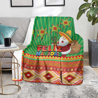 Green Feliz Navidad blanket on gray couch seat with cactus and aztec pattern