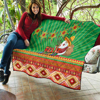 Green Feliz Navidad quilt laid on patio, with aztec border and Santa figure