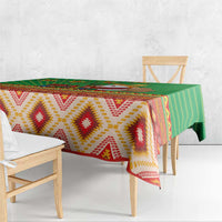 Green tablecloth with zigzag diamond pattern and multicolor southwestern border