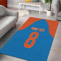 Blue-and-orange area rug featuring a centered '8' motif and 'YOUR TEXT' text