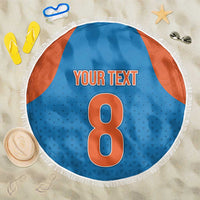 Round blue beach blanket with orange side panels, white fringe edge, large '8' design