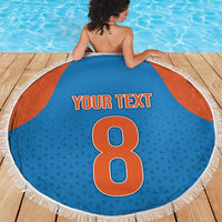 Round blue beach blanket with orange side panels, white fringe edge, 'YOUR TEXT' and 8