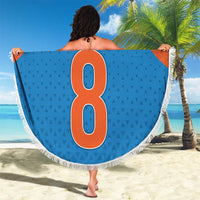 Round blue beach blanket with orange side panels and white fringe, oversized '8' graphic