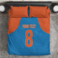 Top view blue and orange bedding set: duvet reads 'Your Text' and shows large 8, with pillowcases