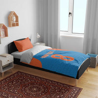 Blue and orange bedding set on a bed: duvet with 'Your Text' and large 8, plus pillowcases