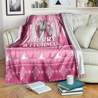 Pink Christmas witch blanket with 'Merry Witchmas' text and silhouettes, draped over couch