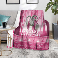 Pink Christmas witch blanket with 'Merry Witchmas' text and witch silhouettes, on rug