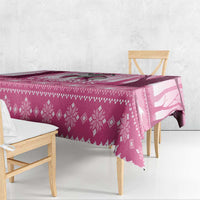 Pink witch-themed Christmas tablecloth draped over a dining table