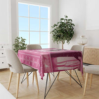 Pink Christmas tablecloth on a dining table with witch and snowflake patterns