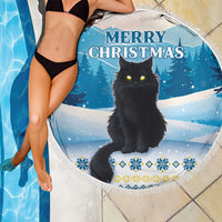 Blue round beach blanket with black cat and Merry Christmas text, fringe edge over swimsuit