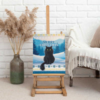 Blue canvas wall art of a black cat sitting on snow with “Merry Christmas”