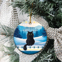 Blue round ceramic cat Christmas ornament on a tree with “Merry Christmas” text