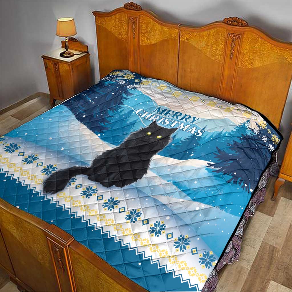 Blue quilt on bed with black cat design and “Merry Christmas” message