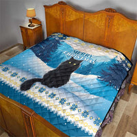 Blue quilt on bed with black cat design and “Merry Christmas” message