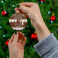 Brown ceramic circle ornament held in hand, showing “Cheer or Fear” Belsnickel design.