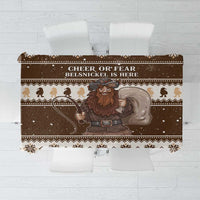 Brown holiday tablecloth with Belsnickel figure, text panel, snow specks, and border