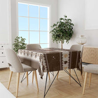 Brown holiday tablecloth draped on dining table with Belsnickel motif and fair-isle trim