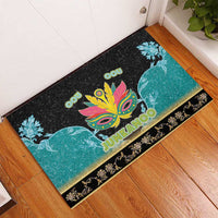 Junkanoo rubber doormat on floor, black with teal whale art, colorful central mask, 'JUNKANOO'