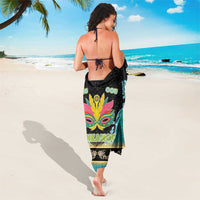 Junkanoo sarong worn lengthwise, black teal fabric with large mask graphic and 'JUNKANOO'