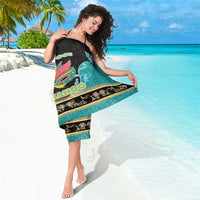Junkanoo sarong detail view, teal and black with colorful mask and gold floral trim