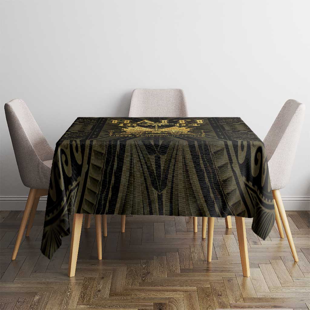 Black and gold tablecloth with geometric and swirl-like pattern on a round dining table.
