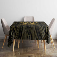 Black and gold tablecloth with geometric and swirl-like pattern on a round dining table.