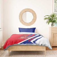 Haiti bedding set on wooden bed: red duvet with coat of arms and HAITI text, plus two blue pillows