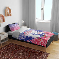 Blue, red and white bedding set on bed with Haiti statue, palm leaves, and floral center