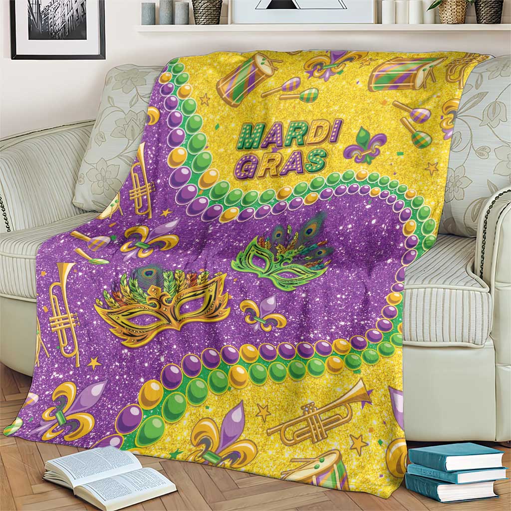 Mardi Gras glitter style blanket, purple and gold with fleur-de-lis masks, beads, and instruments