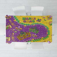 Glitter tablecloth with 'MARDI GRAS' lettering, gold and purple with green swirls and beads.