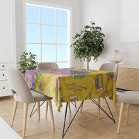 Glitter Mardi Gras tablecloth in gold and purple with green fleur-de-lis, masks, and stars.