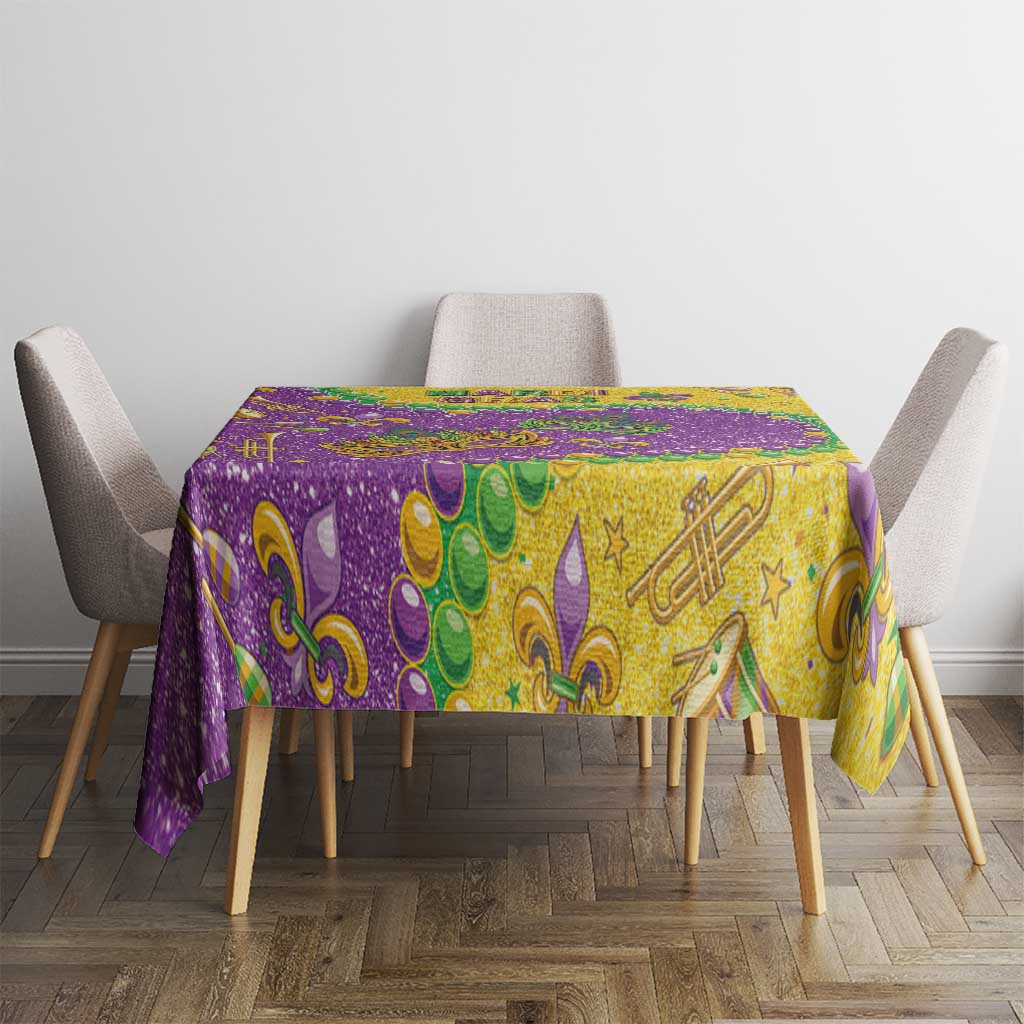 Glitter Mardi Gras tablecloth with gold center and purple edge, star and instrument motifs.