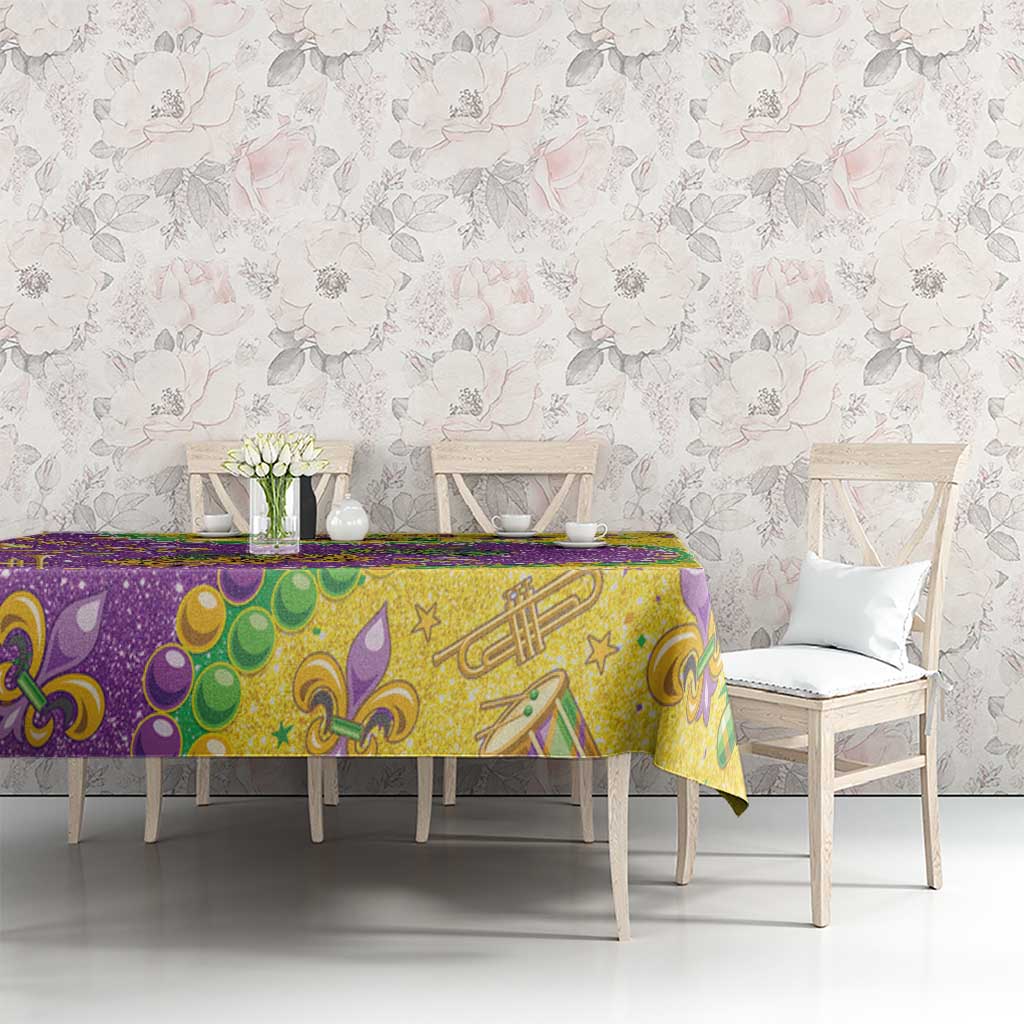 Glitter Mardi Gras tablecloth with yellow-gold and purple print, fleur-de-lis and music icons.