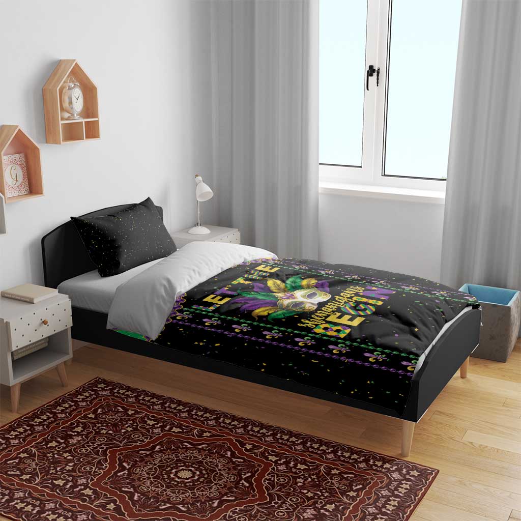 Black Mardi Gras bedding set on a bed with colorful diamond frame and masked face center graphic