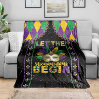 Black Mardi Gras blanket on gray couch with colorful mask, 'Shenanigans Begin' lettering